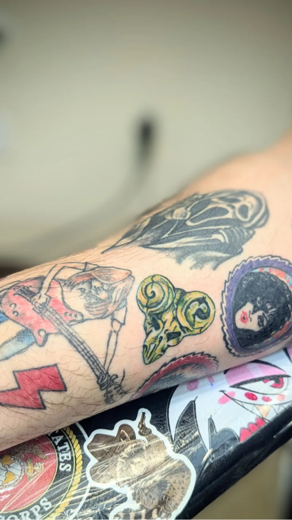 Two tattoo machines and ink on a black background with space for text
